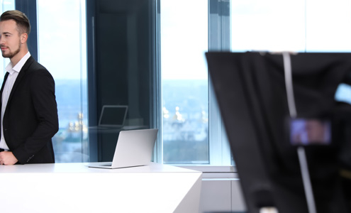 Camera operator filming a corporate video interviewee in a Melbourne office
